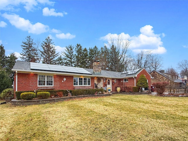 view of front of home with solar panels and a front lawn