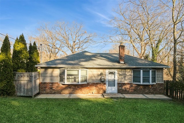 back of property featuring a lawn