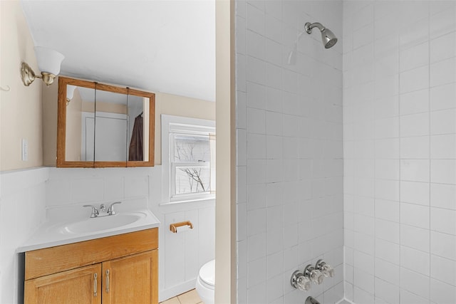 full bathroom with tiled shower / bath, tile patterned floors, vanity, and toilet