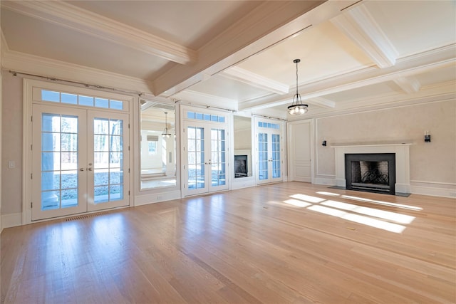 unfurnished living room featuring beam ceiling, french doors, crown molding, and light hardwood / wood-style floors