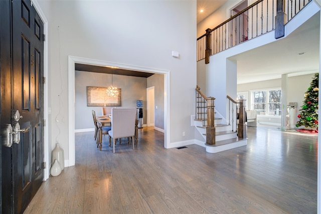 entryway featuring a high ceiling, dark hardwood / wood-style flooring, and a notable chandelier