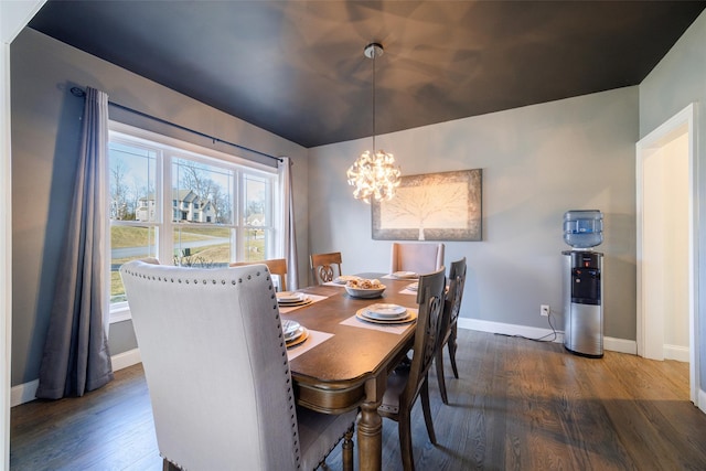 dining room with dark wood-type flooring and an inviting chandelier