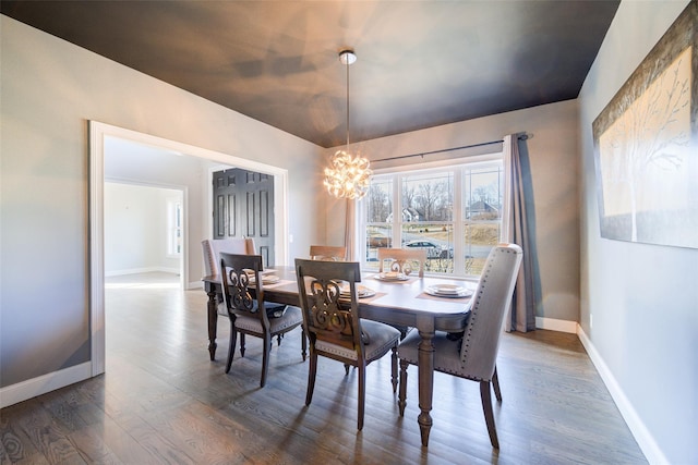 dining space with dark wood-type flooring and a notable chandelier