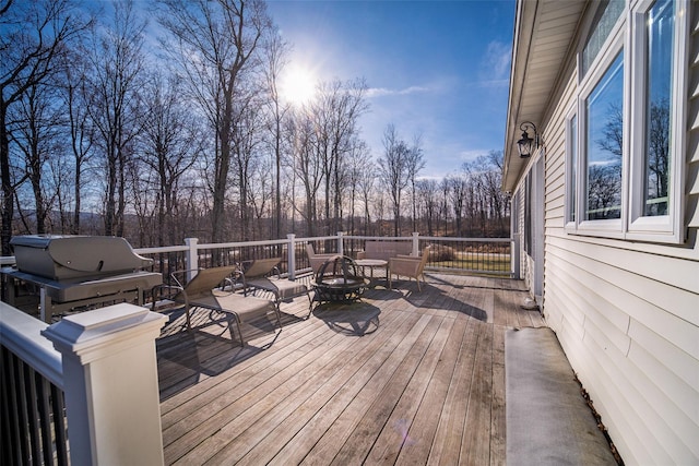 deck with grilling area and an outdoor fire pit