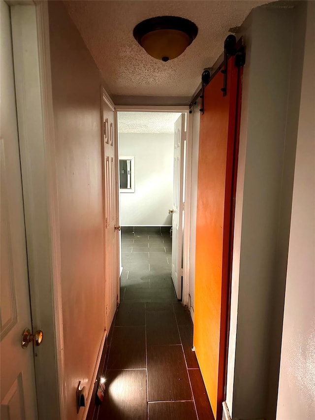 hall featuring a textured ceiling and a barn door