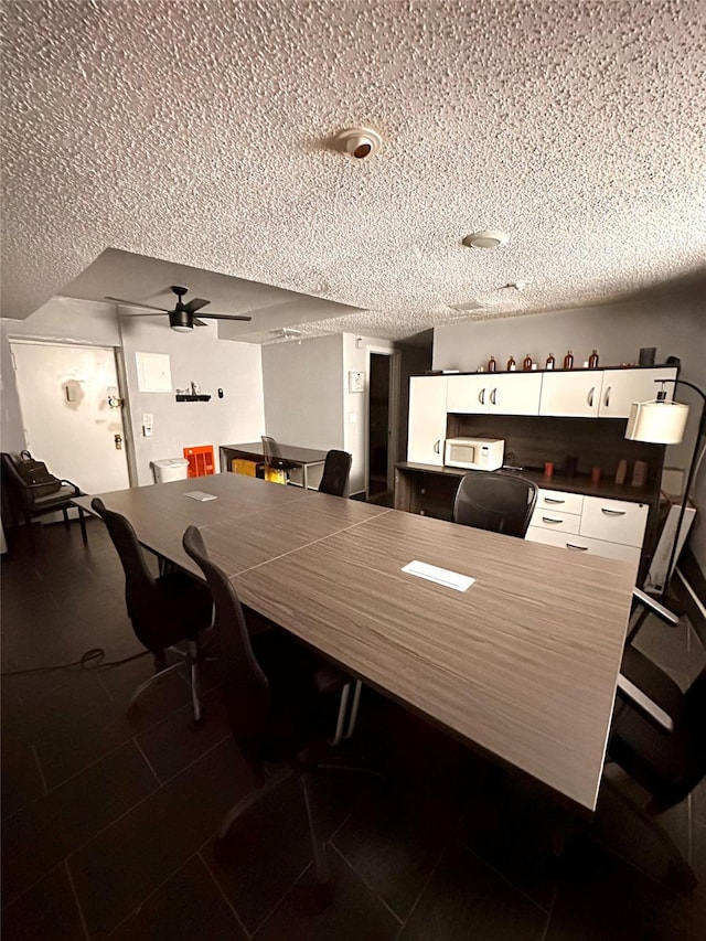 dining space with a textured ceiling and ceiling fan