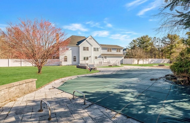 exterior space with a patio area, a lawn, and a covered pool