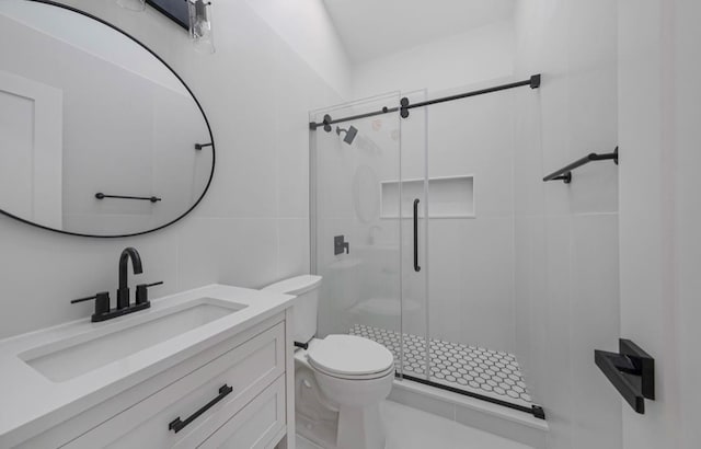 bathroom featuring toilet, a shower with shower door, tile walls, and vanity