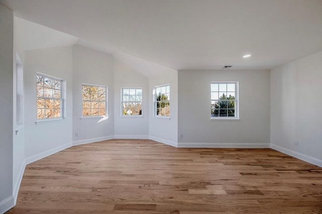 empty room featuring light hardwood / wood-style floors and vaulted ceiling