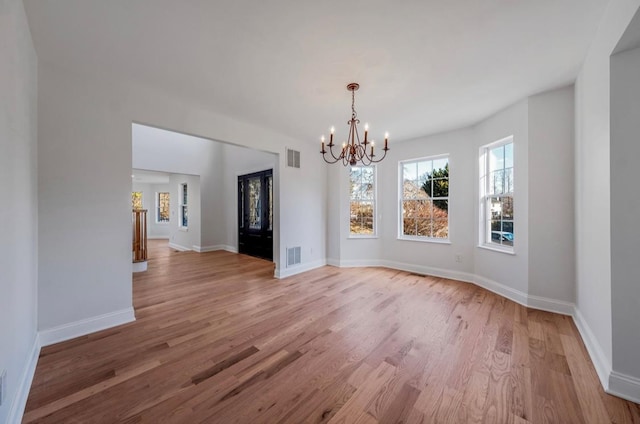 unfurnished dining area featuring a notable chandelier and light hardwood / wood-style floors