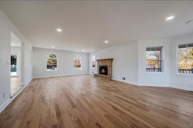 unfurnished living room with a fireplace and light wood-type flooring