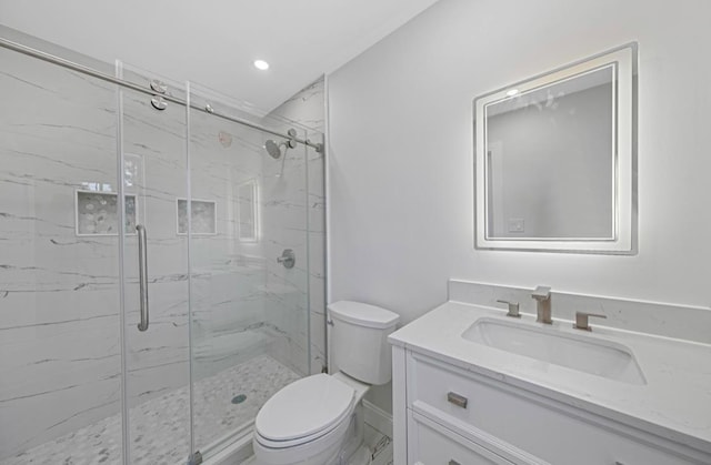 bathroom with a shower with door, vanity, and toilet