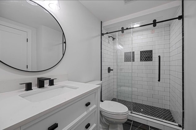 bathroom featuring walk in shower, vanity, tile patterned floors, and toilet