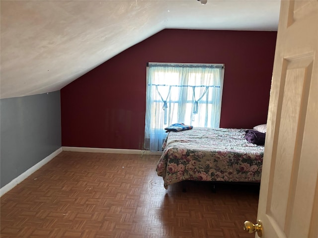 bedroom with lofted ceiling and parquet floors