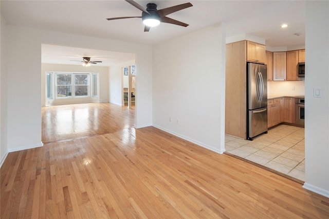 kitchen featuring light hardwood / wood-style floors, stainless steel appliances, and ceiling fan