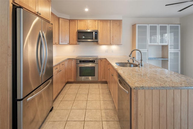 kitchen with appliances with stainless steel finishes, ceiling fan, sink, light stone counters, and light tile patterned floors