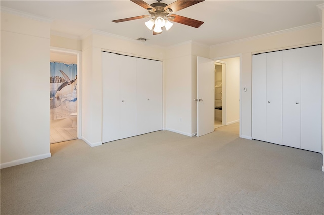 unfurnished bedroom featuring ceiling fan, light colored carpet, crown molding, and connected bathroom