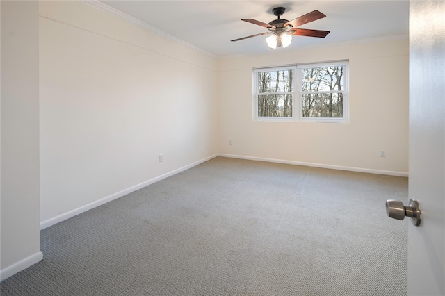 carpeted spare room with ceiling fan and crown molding