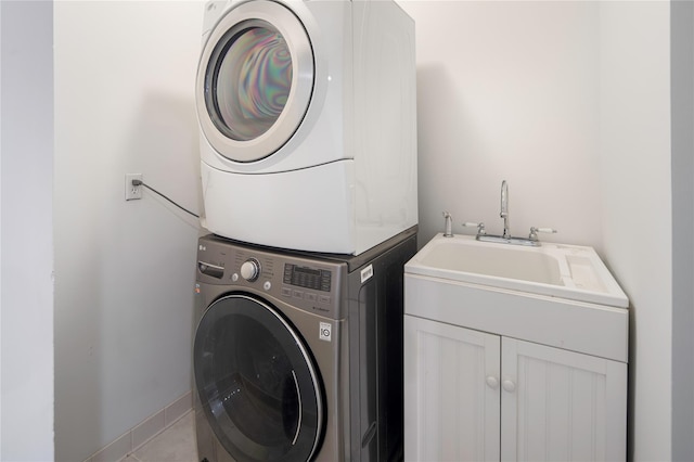 laundry room featuring stacked washer and clothes dryer and light tile patterned flooring