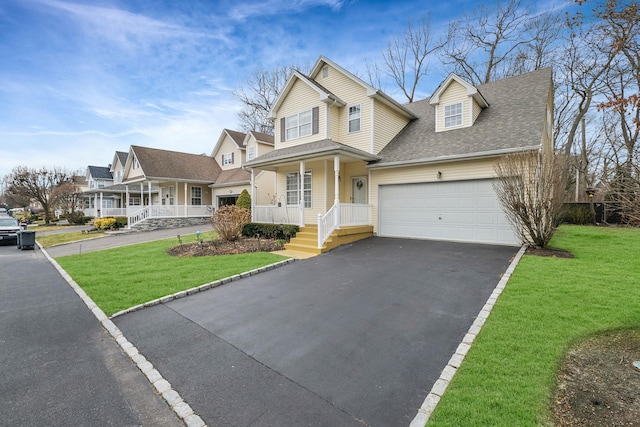 view of front of property featuring a garage, covered porch, and a front lawn