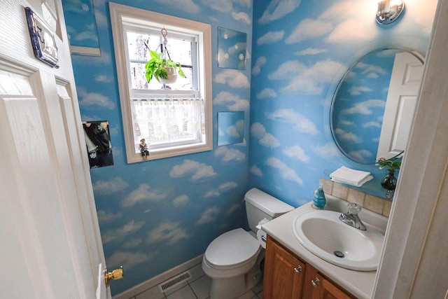 bathroom with toilet, vanity, and tile patterned floors