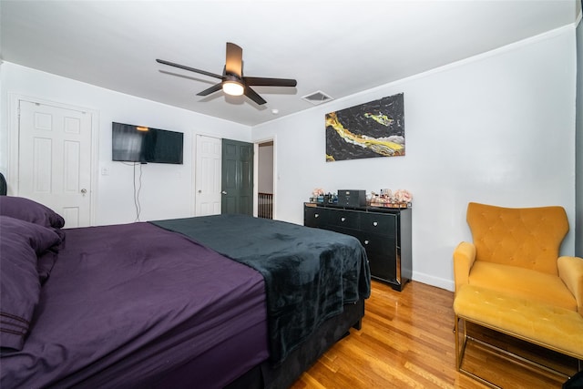 bedroom featuring ceiling fan, light hardwood / wood-style flooring, and ornamental molding