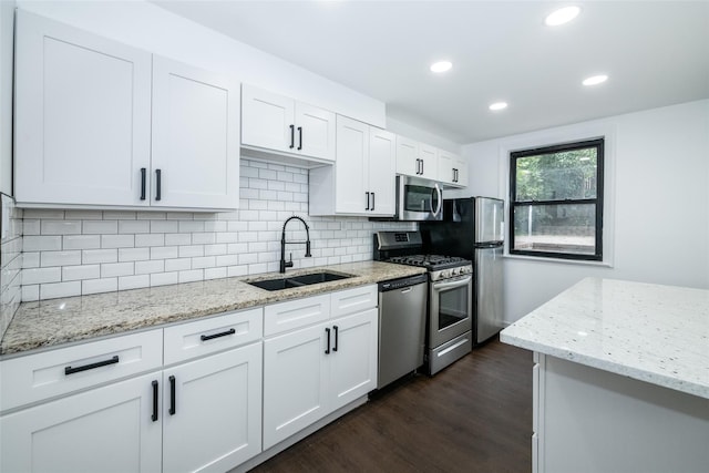 kitchen featuring light stone counters, sink, white cabinets, and stainless steel appliances