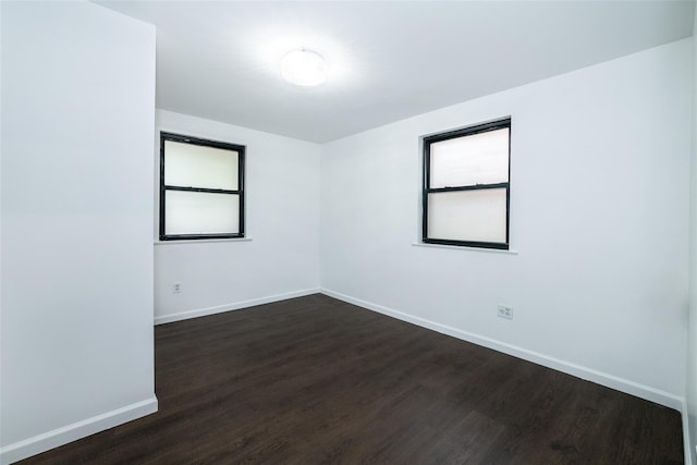 unfurnished room with dark hardwood / wood-style flooring