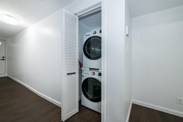 laundry area featuring stacked washer / dryer and dark hardwood / wood-style flooring