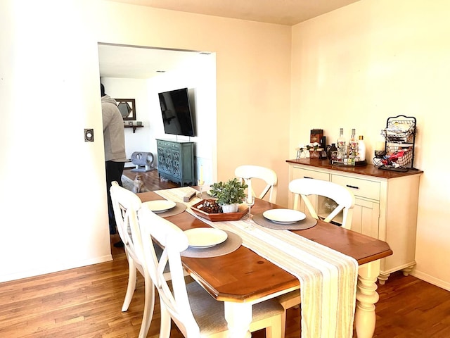 dining space with baseboards and light wood-style floors