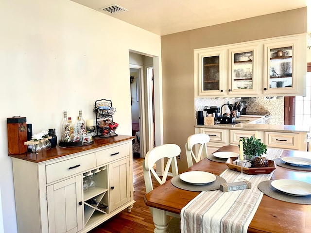 dining space featuring dark wood-type flooring and visible vents