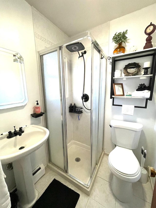 full bathroom featuring toilet, a shower stall, a baseboard heating unit, and tile patterned floors