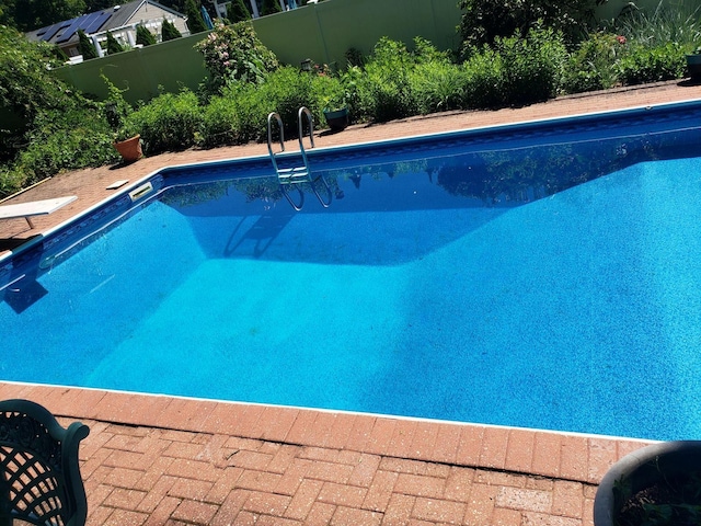 pool featuring a fenced backyard and a diving board