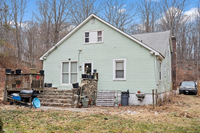 rear view of property featuring a wooden deck