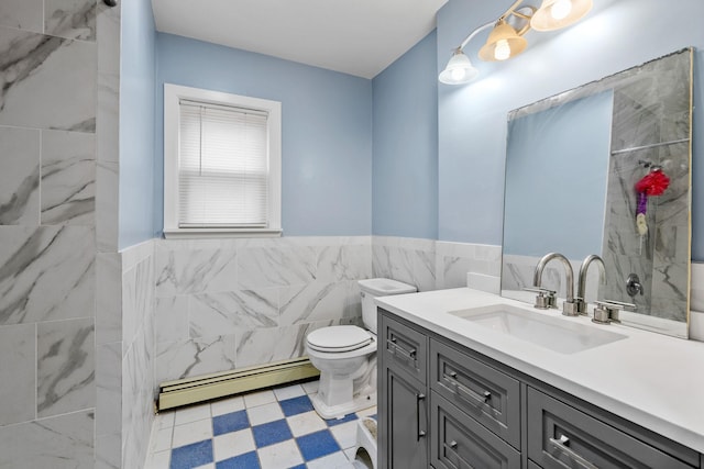 bathroom with tile walls, a baseboard radiator, vanity, and toilet