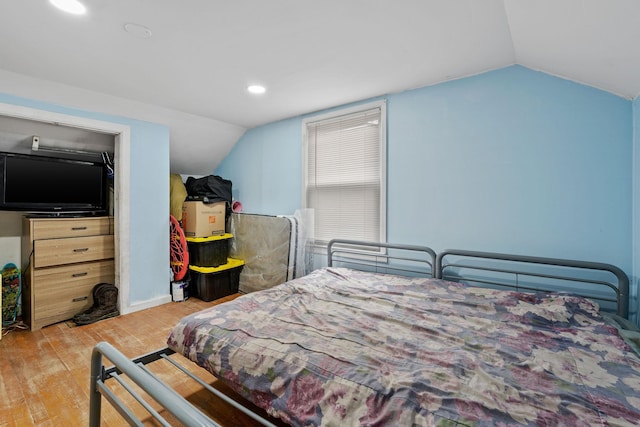 bedroom with lofted ceiling and light hardwood / wood-style floors