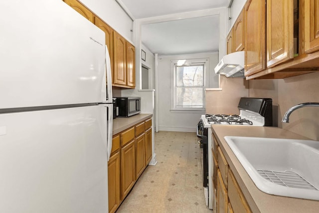 kitchen with white refrigerator, sink, and black gas stove