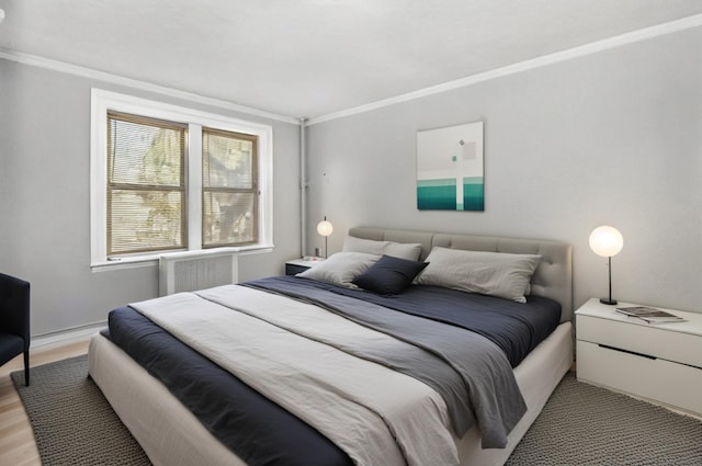 bedroom featuring light wood-type flooring and crown molding