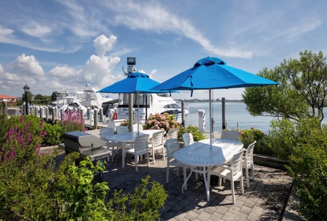 view of patio featuring a water view and a dock