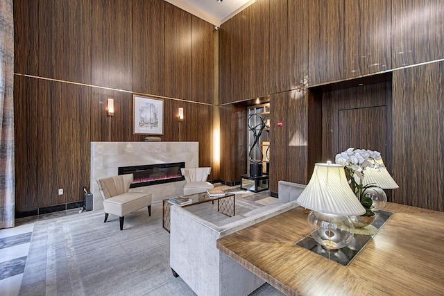 living room featuring a towering ceiling and wood walls