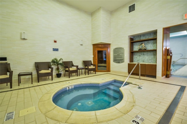 view of swimming pool featuring an indoor hot tub