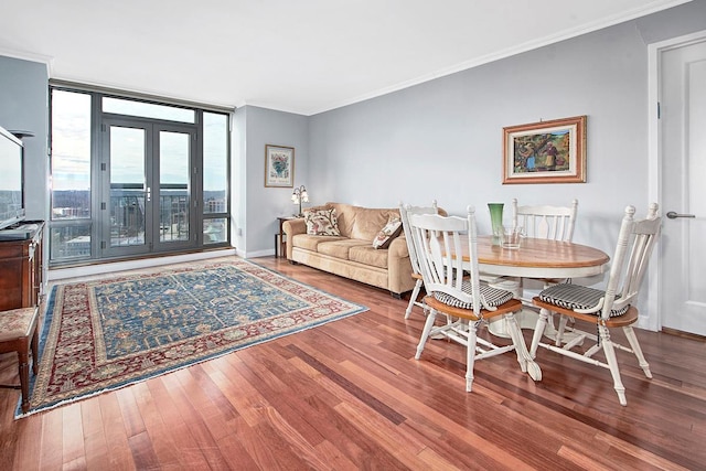 dining space featuring hardwood / wood-style flooring, crown molding, and a wall of windows