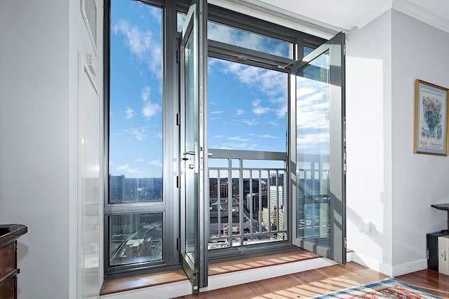 doorway with crown molding, wood-type flooring, and floor to ceiling windows