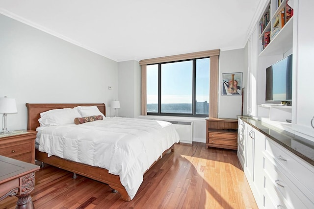 bedroom featuring crown molding and light wood-type flooring