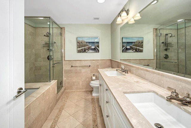 bathroom featuring tile walls, tile patterned flooring, vanity, an enclosed shower, and toilet