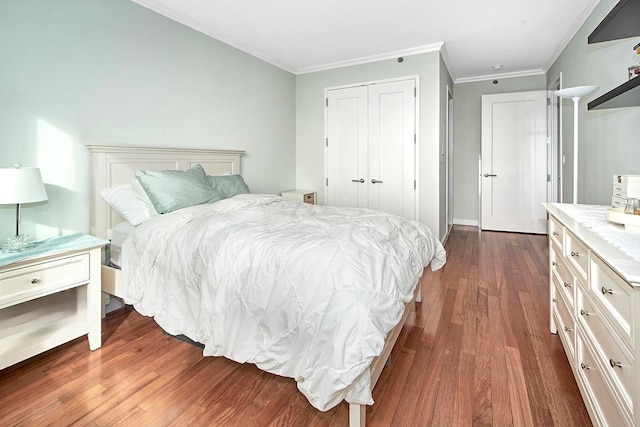 bedroom featuring dark wood-type flooring, ornamental molding, and a closet