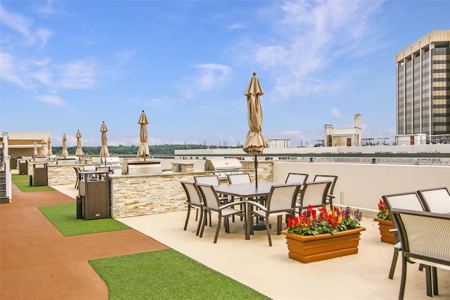 view of patio / terrace featuring a bar, area for grilling, and an outdoor kitchen