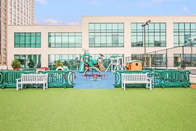 back of house with a playground and a yard