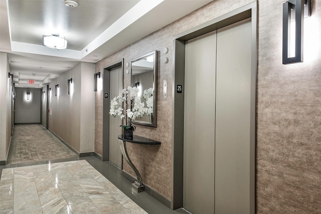 corridor with baseboards and elevator
