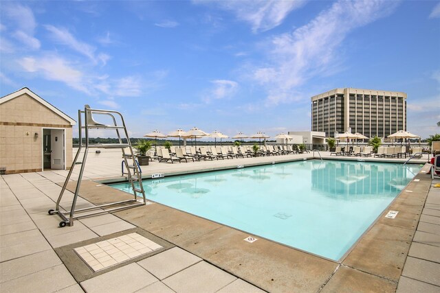 community pool featuring fence and a patio